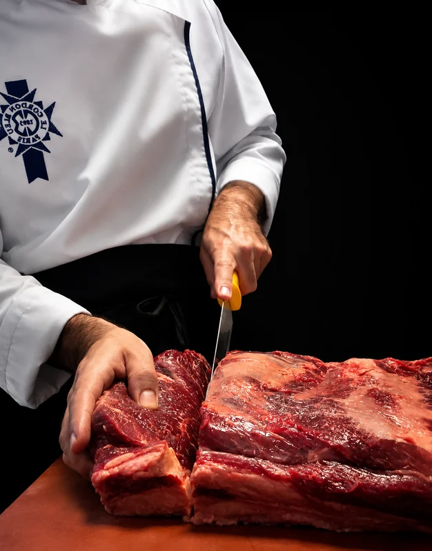 Chef cortando carne en Cañete
